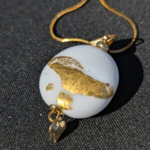 Pendentif rond en verre blanc avec feuille d’or et chaîne dorée